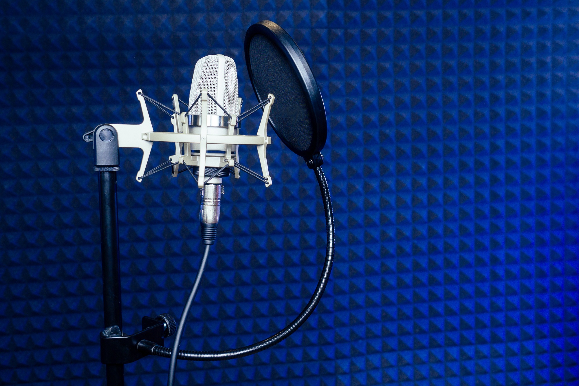 Microphone and headphone in a recording studio soundproof wall.